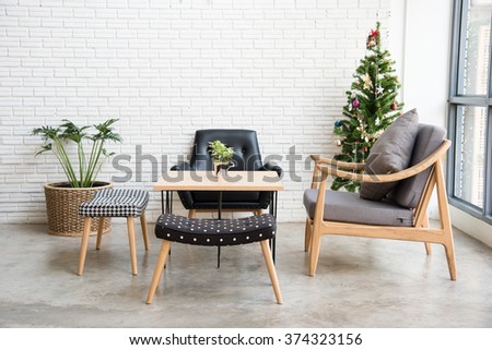 cozy sofa corner with christmas tree decoration at the back. sofa is in modern style and made with wood.