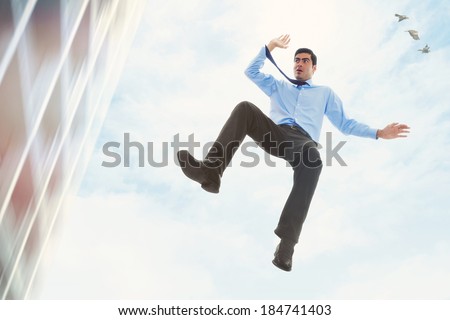 Stock image of businessman falling off a building