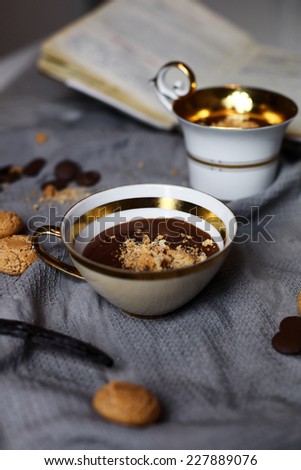 Chocolate pudding in vintage cups with amaretto biscuits on a grey linen cloth. Food styling photography.