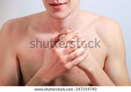 young man\'s naked chest and hands