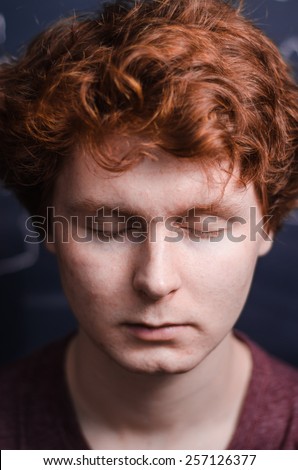 red head guy portrait with eyes closed on a chalkboard background