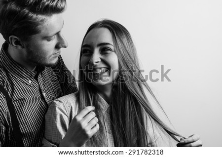 beautiful young couple laughing in love studio portrait black and white bw