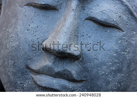 Smiling Stone Buddha Statue face with closed eyes from Indonesia looking to the left