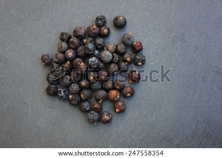 Dried fruits organic juniper berries (juniperus fructi from albania & macedonia) on a slate stone background