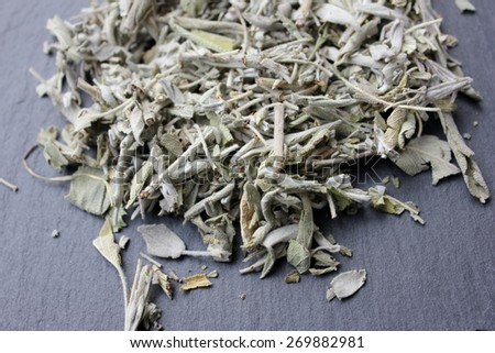 Dried sage plant (salvia officinalis) leaves (whole herb) for incense or herbal tea infusion on a grey slate stone background, natural feeling used by the ancient native indians for rituals