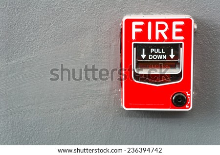 Fire alarm switch on gray wall