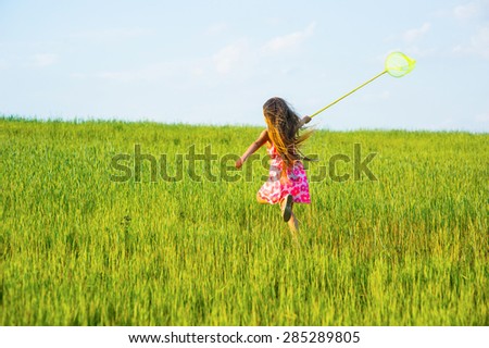 Girl with a butterfly net catching butterflies.