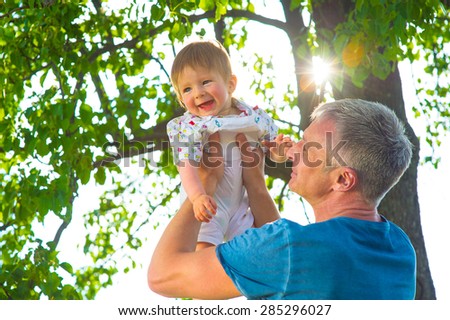 Dad playing with his son in the garden. Man with  baby.