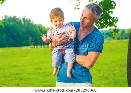 Father and son on a walk. Kid in the hands of his father.