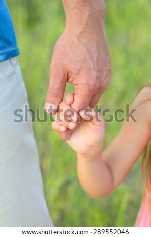 Daughter holds the hand of his father. Dad and daughter.