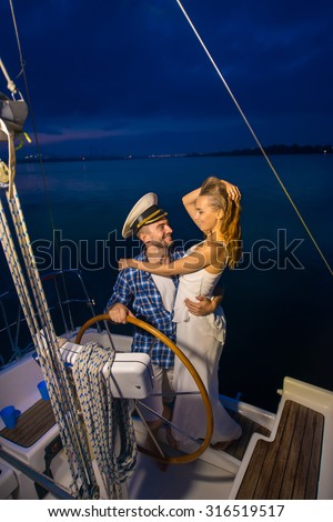 Romantic trip on a yacht. Night walk along the river. Loving couple on a yacht. Honeymoon on the yacht.