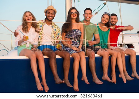 Loving couples relaxing on a yacht. Happy young people sailing on the yacht. Beautiful guys and girls spend the weekend on a yacht. Cruise on a yacht at sea. Party on a yacht.
