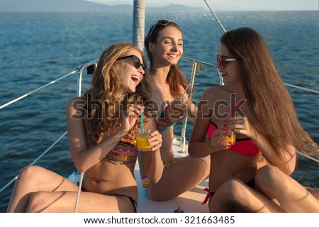 Girlfriends rest on the sea. Girls enjoy the vacation on a yacht. Tourists sunbathing on the yacht. Party on a yacht. Corporate party on a yacht.