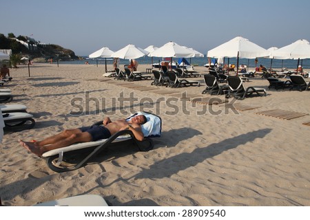 The man on the beach bed with his eyes closed. Relax. Sunset.