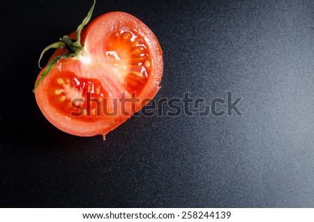 cut tomato on a black matte background