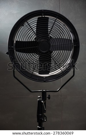 modern fan standing right at the camera. On a black background