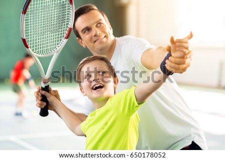 Happy child playing sport game with his parent