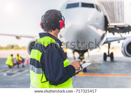 Male worker controlling aircraft and writing information