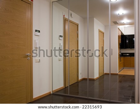 Modern hallway with mirrors and entrance door