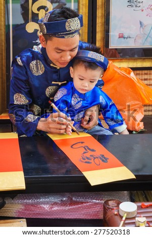 Family painter artist/HoChiMinh, Vietnam   February 9th 2015: This artist and his son were painting the image in his shop, in HoChiMinh, Vietnam