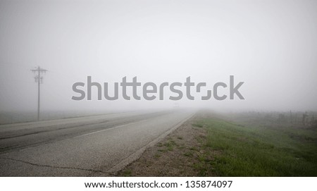 Dense fog covers a highway in rural New Mexico.