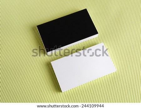 Blank black and white business cards on a green background.