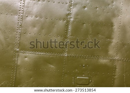 Military green metal plates background texture with seams and rivets. Riveted metal from aircraft.