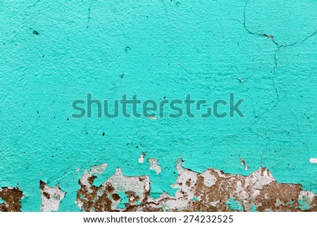 Turquoise texture. Peeling paint background.  A fragment of the old wall, painted bright turquoise paint, cracked over time.