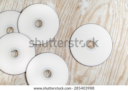 Blank printable CD and DVD on light wooden background. Top view.