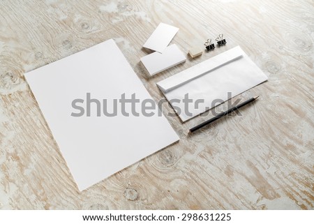 Blank stationery set on light wooden background. For design presentations and portfolios. Top view.