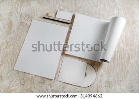 Photo of branding identity set on light wooden background. Blank template for design presentations and portfolios. Top view.