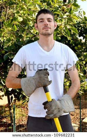 Man holding garden tools/Man working in Garden/Man working in his garden during the early morning