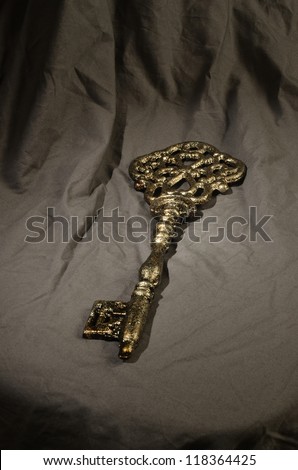 Old key on a cloth/Vintage Key/Key bathed in mysterious lighting