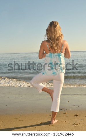 Young Woman at a beach Doing Yoga/Yoga Evening/Healthy young woman does her yoga at a beach