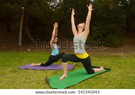 Woman doing outdoor yoga/Outdoor Yoga.Two woman are engaged in yoga in outdoor setting