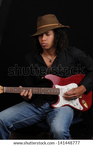 Young Afro American Guitar Player/Serious Guitar Player/Young man demonstrates his guitar skills as a musician.