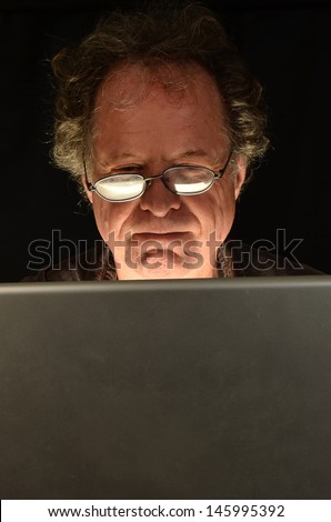 Suspicious older Man on Computer/Mature Man Computer/Man is looking at his computer for emails and internet
