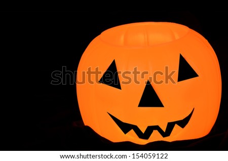 Glowing orange pumpkin/Halloween Smile/Orange pumpkin with face on a black backgrounf