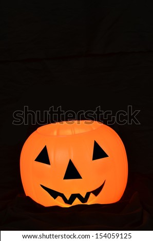 Glowing orange pumpkin/Halloween Smile/Orange pumpkin with face on a black backgrounf