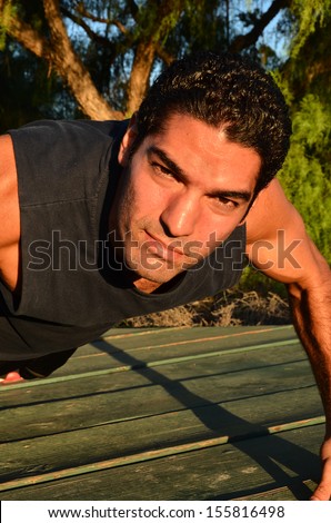 Young man exercising in outdoor environment.Physically Fir Man/Young man doing his exercises in an outdoor environment