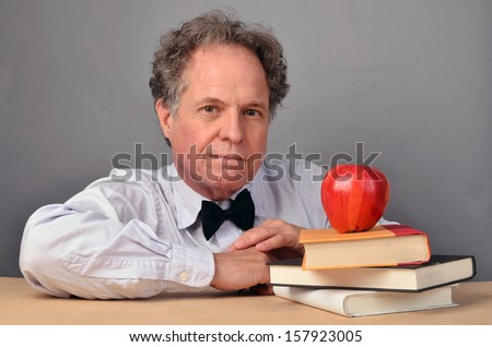 Mature man with books acting as a teacher/Mature Teacher/Man is a mature teacher character