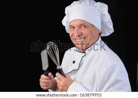 Mature chef in whites with kitchen utensils/Mature Master Chef/Older man in chef\'s white with kitchen utensils
