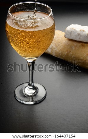 Glass with white sparkling wine/Wine Bread and Cheese/White sparkling wine with bread and cheese in the background