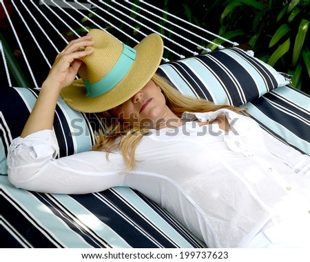 Woman with hat is lying on a hammock/Resting Woman/Woman with a hat is lying on a hammock on a summer day