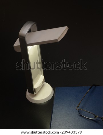 LED reading lamp with book and reading glasses/Night Reading/Reading lamp with book and glasses in an evening environment