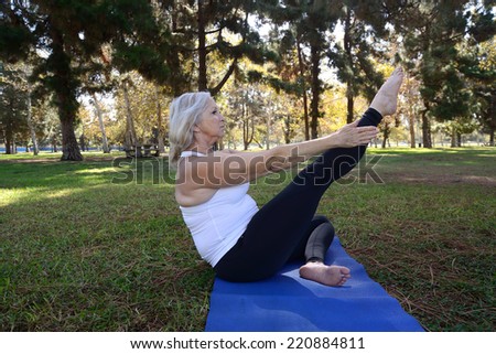 Woman demonstrate her yoga postures/Senior Yoga/Senior woman in a park setting is doing her yoga