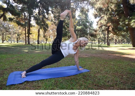 Woman demonstrate her yoga postures/Senior Yoga/Senior woman in a park setting is doing her yoga