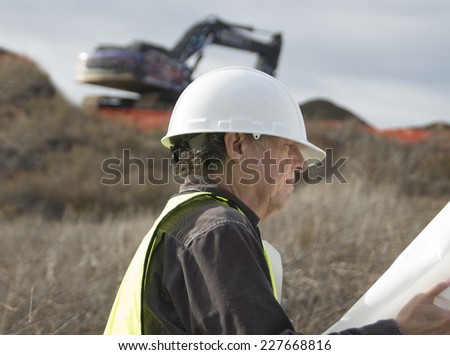 Senior construction man on a job site/Serious Construction Worker/Senior man with hard hat
