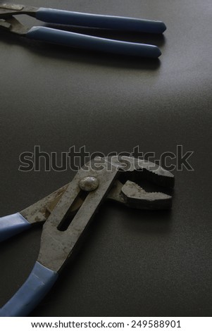 Pliers on black surface/Rusted Pliers/Rusted well used tools on a black surface
