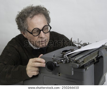 Man working on a vintage typewriter/Author Working on Typewriter/Man with glasses working on typewriter